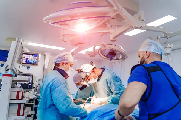 Grupo de cirurgiões em centro cirúrgico com equipamento cirúrgico. Contexto médico — Fotografia de Stock