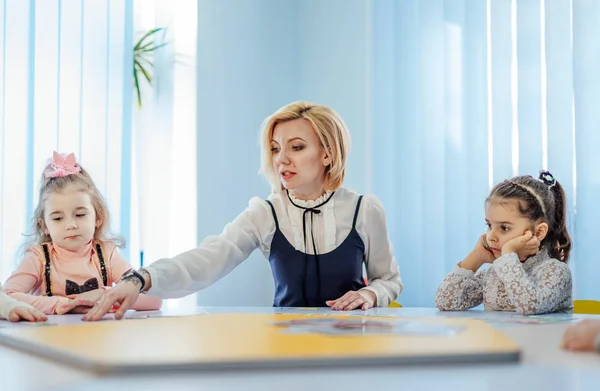 Jonge vrouwelijke leraar die met kinderen op school werkt. Basisschool — Stockfoto