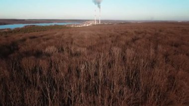 Elektrik santrali sonbaharda nehrin ve ormanın arka planında çalışıyor. Hava görünümü