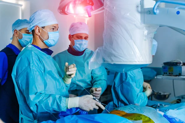Spine Surgery. Group of surgeons in operating room. Modern equipment in operating room.
