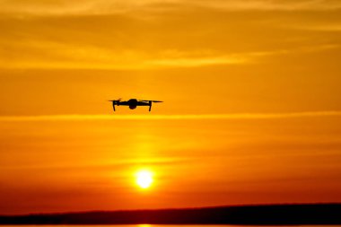 drone quadcopter günbatımında uçan dijital fotoğraf makinesi ile