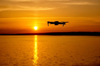 Güneş batımında uçan drone. Güneş batımında uçan dijital kamera ile drone quadcopter