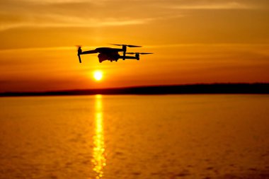 güneş batımında uçan dijital kamera ile drone quadcopter. Nehirde güzel gün batımı