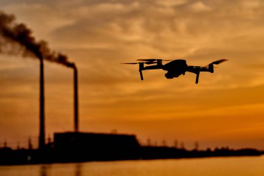 gün batımının arka planına karşı drone silueti. Gece gökyüzünde uçan drone.