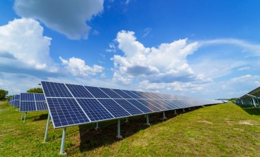 Mavi gökyüzü arka plan üzerinde güneş paneli. Yeşil çimenler ve bulutlu gökyüzü. Alternatif güneş enerjisi konsepti