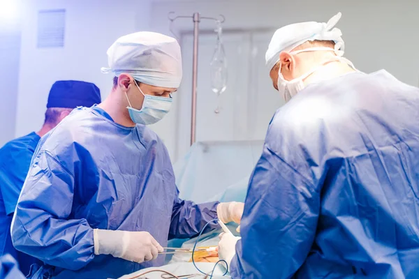 Groupe de chirurgiens en salle d'opération avec équipement chirurgical. Un passé médical moderne. En chirurgie. — Photo