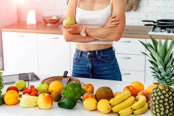 Vacker livlig kvinna förbereder fruktjuice från färska råvaror i hennes kök i en hälsosam kost och livsstil koncept — Stockfoto