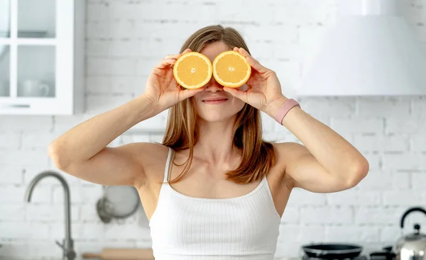 Frau hält Orangen vor Augen — Stockfoto