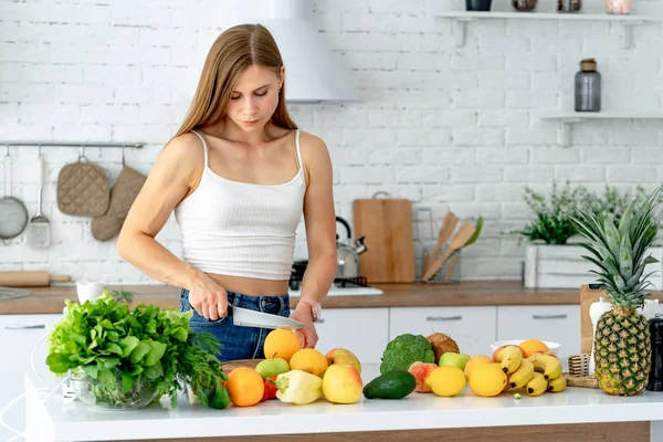 Χαριτωμένο υγιές κορίτσι με φρούτα και λαχανικά στην κουζίνα. Υγιεινές τροφές και δίαιτες — Φωτογραφία Αρχείου