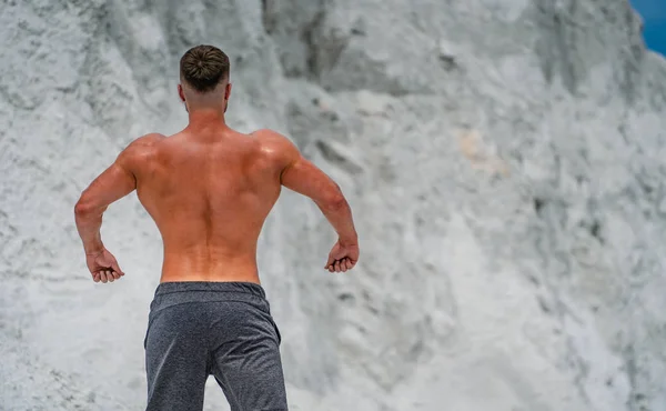 La doble pose del bíceps de la espalda del hombre. Culturista profesional posando —  Fotos de Stock