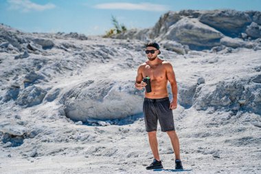 Güçlü, atletik bir adam çıplak gövdeyle ayakta duruyor. Güzel sağlıklı vücut kavramı.