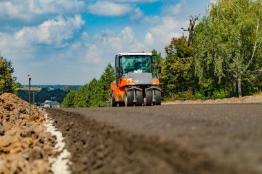 Yol inşaatında yol silindiri. Otoyolun yapımı ve onarımı.