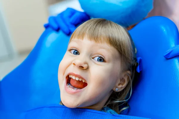 Menina bonito na clínica dentária. Criança em armário estomatológico com boca aberta. Emoção feliz . — Fotografia de Stock