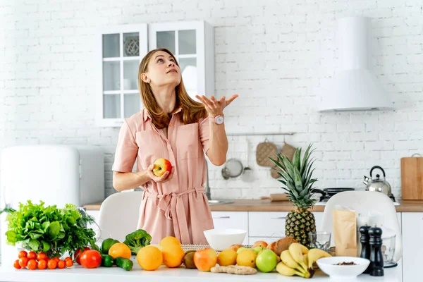 Mujer en cocina lista para preparar comida con verduras y frutas. Mujer con una manzana . — Foto de Stock
