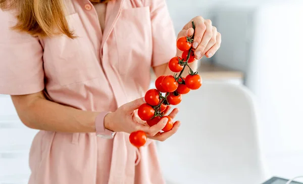 手に枝に美しい赤いトマト. — ストック写真