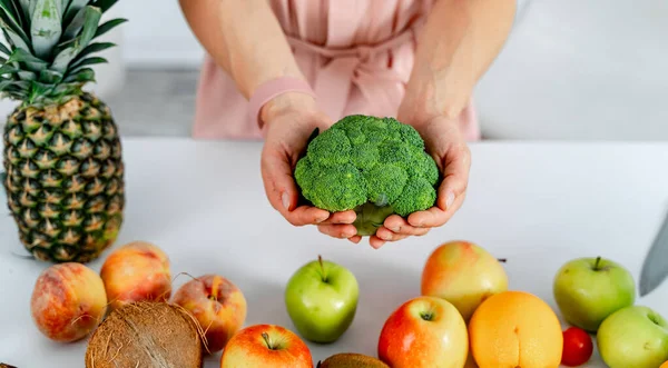 Belo brócolis verde fresco nas mãos. Frutas e verduras em uma mesa . — Fotografia de Stock