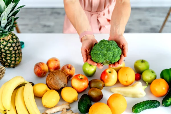Belo brócolis verde fresco nas mãos. Frutas e verduras em uma mesa. Fechar — Fotografia de Stock