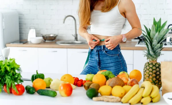 Conceito de dieta. Mulher bonita perto na cozinha com comida saudável. Frutas e produtos hortícolas . — Fotografia de Stock