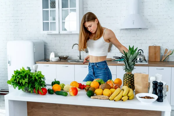 Conceito de dieta. Mulher bonita perto na cozinha com comida saudável. Frutas e produtos hortícolas . — Fotografia de Stock