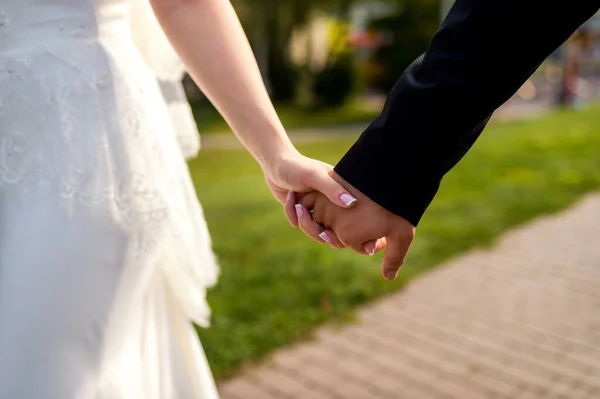 Tema pernikahan, memegang tangan pengantin baru. Berjalan bersama. Pengantin pria dan wanita . — Stok Foto
