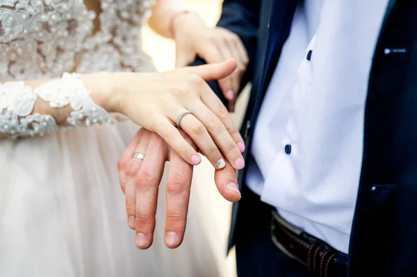 Mãos com alianças de casamento. Fotosessão de noivas e noivas . — Fotografia de Stock