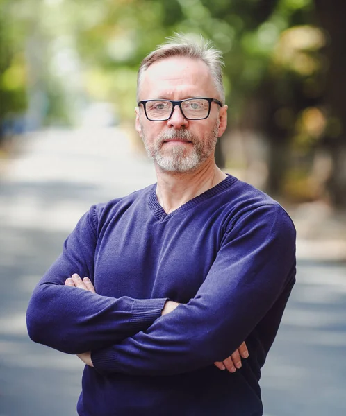 Bel homme d'âge moyen avec les cheveux gris dans un cadre extérieur . — Photo