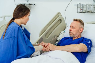 Kızı, büyük babasını hastanede ziyaret ediyor. Ziyaretçi ve bir hasta. Aile desteği. Dikkat.