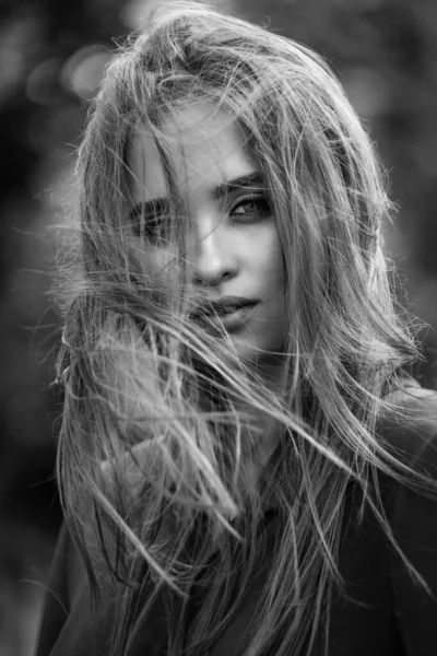 Beauty portrait of a young beautiful brunette girl with long black straight flying hair. Magnificent hair. Black and white — Stock Photo, Image