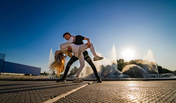 一对年轻夫妇在高速公路上跳舞。 飞毛腿 电影。 男人把女人抱在一起跳舞. 人的情感。 激情之舞. — 图库照片