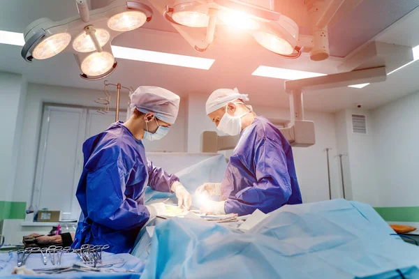 Proceso de operación quirúrgica con equipo médico. Dos cirujanos en quirófano con equipo quirúrgico. Formación médica . — Foto de Stock