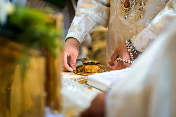 Nozze chiesa cerimonia concetto. Tazza d'oro con vite sul piatto. Sfondo sfocato. Primo piano . — Foto Stock