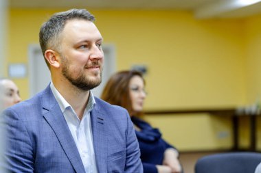 Ofisteki genç başarılı iş adamının portresi. Seminerdeki yakışıklı adam. Arka plan bulanık. Sakallı, kendine güvenen adam..