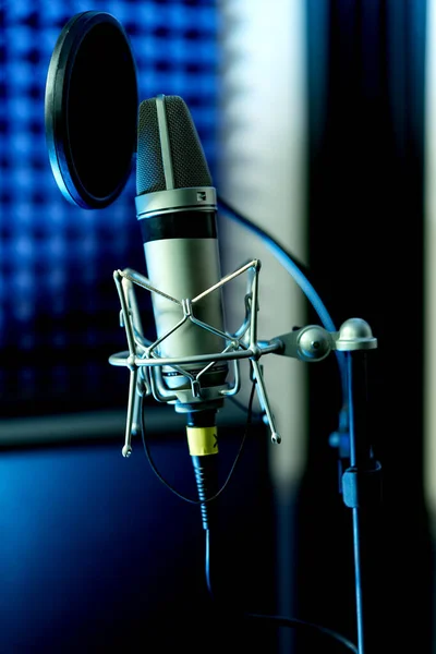 Primer plano micrófono de condensador de estudio con filtro pop y montaje anti-vibración grabación en vivo con luces de color de fondo. Vista lateral —  Fotos de Stock