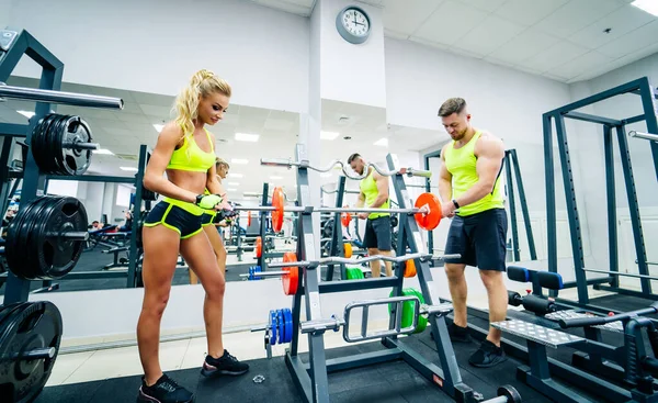 Entrenador y cliente en el gimnasio con equipamiento deportivo. Joven y en forma. Concepto de vida saludable fitness. — Foto de Stock