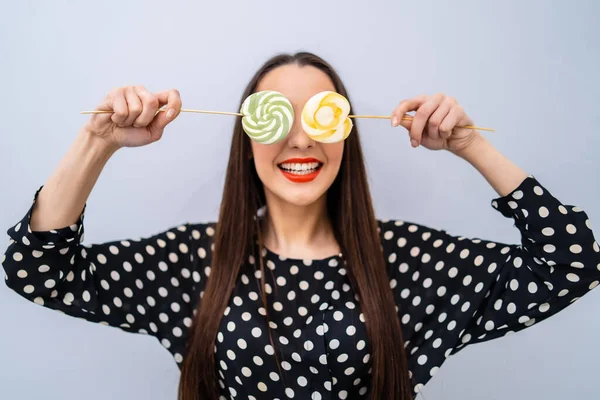 Mädchen Hält Zwei Lutscher Augennähe Fröhliche Dame Gepunkteten Hemd Vor — Stockfoto