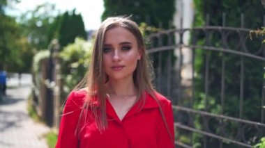 Yazın genç ve çekici bir kadının portresi. Uzun saçlı güzel bir kadın kendi etrafında mutlu bir şekilde dönüyor. Sokakta yürüyen güzel bir kadın.