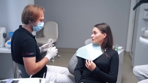 Pretty Woman Talking Stomatololist Male Dentist Showing Artificial Jaw Patient — Stock Video