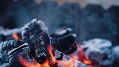 Şenlik ateşinde siyah kömür. Beyaz kağıt listesi ateşe düşüyor ve ışıl ışıl yanıyor. Yavaş çekim.