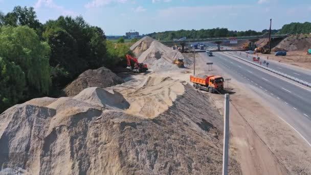 道路の近くの瓦礫の山 トラックの石の高速道路に出て移動のフル 多くの車が道路を走っている 空中風景 — ストック動画