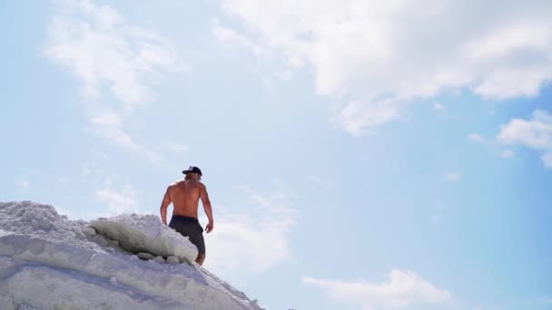 赤身裸体的男人下山去了 在蓝天下的群山中 你可以看到强壮的运动员 从下面看慢动作 — 图库视频影像