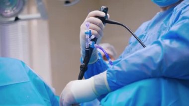 Uzman, laparoskopik ameliyat sağlıyor. Yeni tıbbi ekipmanlarla karın cerrahi müdahalesi. Doktorun elindeki yakın çekim aleti. Tıpta yeni teknolojiler.