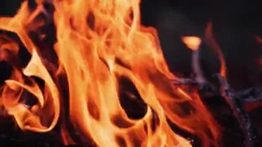 Yanan ateş. Şenlik ateşi. Siyah arkaplanda yanan alevlerin yakınlaşması, yavaş çekim