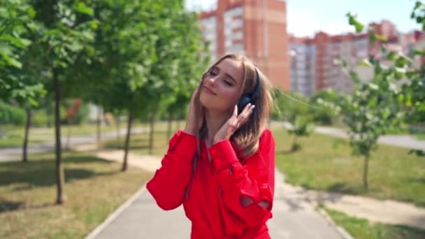 Dışarıda Müzik Dinleyen Güzel Bir Kız Sokakta Duran Siyah Kulaklıklı — Stok video
