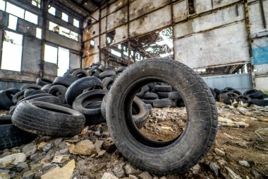 Hasarlı bir fabrikadaki araçlar için artık uygun olmayan lastikler. Arabadaki plastik döküntüler..