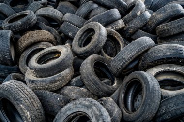 Bozuk fabrikada büyük bir araba lastiği yığını. Eski büyük boş binanın içinde yerde bir sürü siyah lastik lastik lastik vardı..