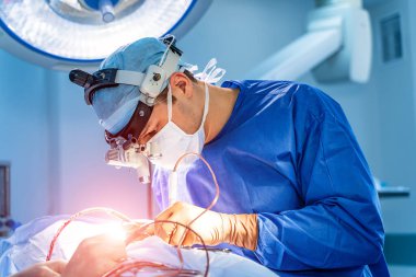 Ameliyathanede çalışan bir cerrah. Ameliyathanede modern ekipman var. Nöroşirürji için tıbbi cihazlar.