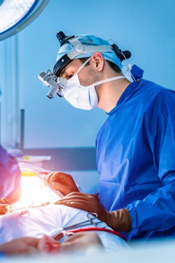 Ameliyathanede çalışan bir cerrah. Ameliyathanede modern ekipman var. Nöroşirürji için tıbbi cihazlar.