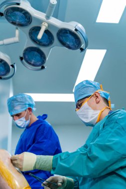 Ameliyathanede ameliyat ekipmanlarıyla bir grup cerrah. Tıbbi geçmiş