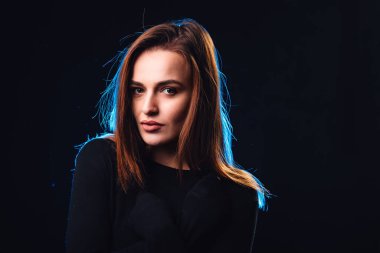 Mükemmel özellikleri olan çekici bir kadının güzel portresi. Siyah stüdyo arka planına bakıyor. Uzun saçlı manken kız..