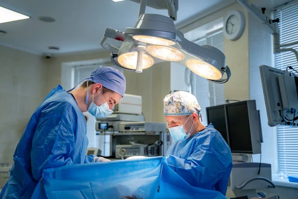Equipo Cirujanos Realizando Operación Sala Cirugía Moderna Luminosa Teatro Operaciones — Foto de Stock